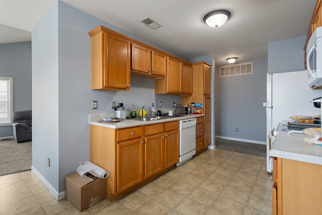 kitchen featuring white appliances and sink