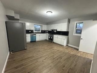 kitchen with stainless steel appliances, dark hardwood / wood-style floors, white cabinets, and backsplash