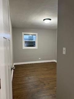 unfurnished room with dark wood-type flooring