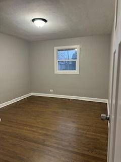 spare room with dark hardwood / wood-style flooring