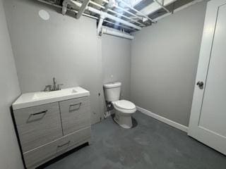 bathroom featuring vanity, concrete floors, and toilet