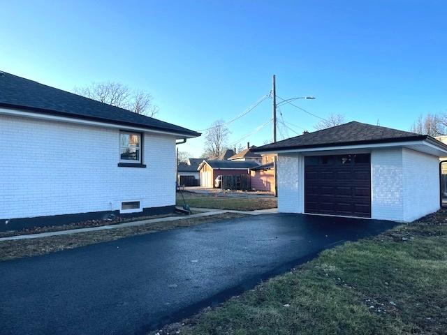 view of property exterior with a garage and an outbuilding