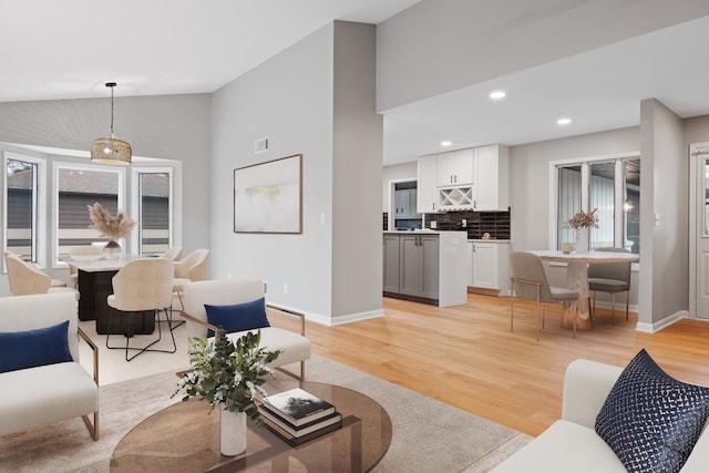 living room featuring light hardwood / wood-style flooring and lofted ceiling