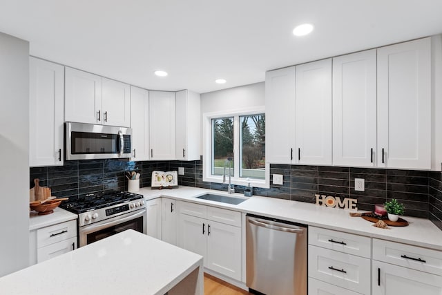 kitchen featuring sink, white cabinets, tasteful backsplash, and appliances with stainless steel finishes