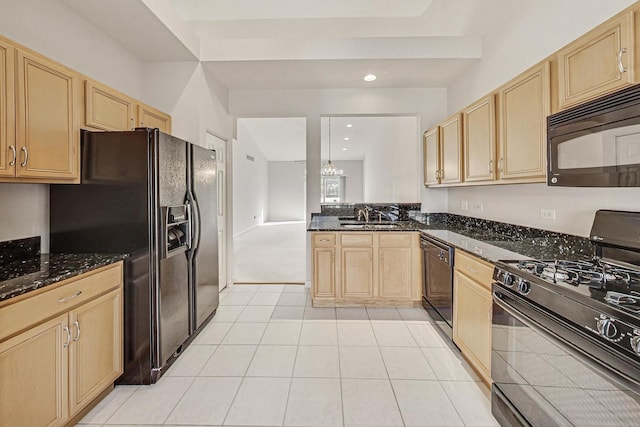 kitchen with sink, dark stone countertops, light tile patterned floors, a notable chandelier, and black appliances