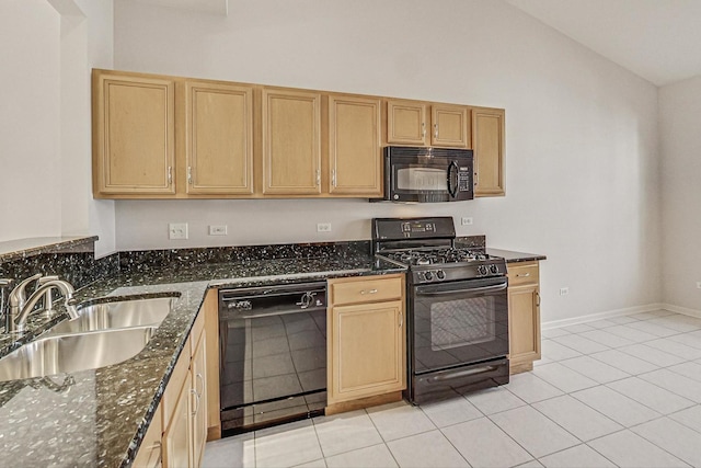 kitchen with light tile patterned flooring, sink, vaulted ceiling, dark stone countertops, and black appliances