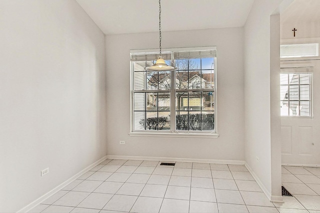 unfurnished dining area featuring light tile patterned flooring and plenty of natural light