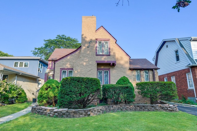 tudor home with a front lawn