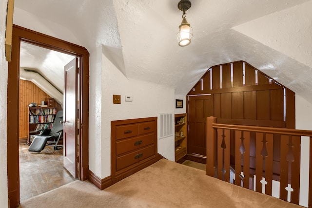 interior space with light colored carpet and vaulted ceiling