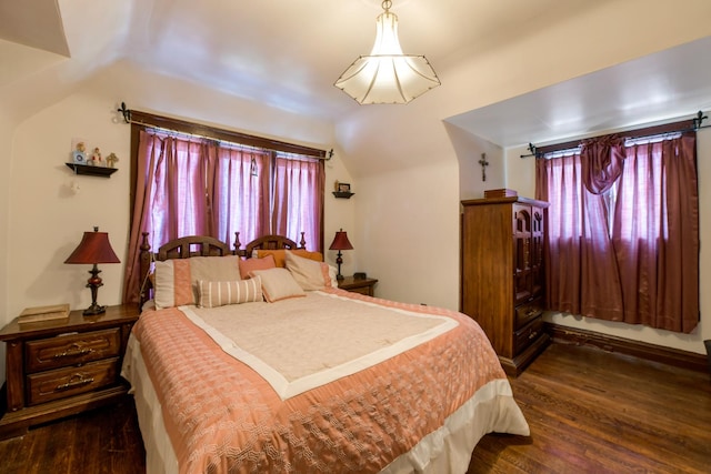 bedroom with dark wood-type flooring, multiple windows, and lofted ceiling