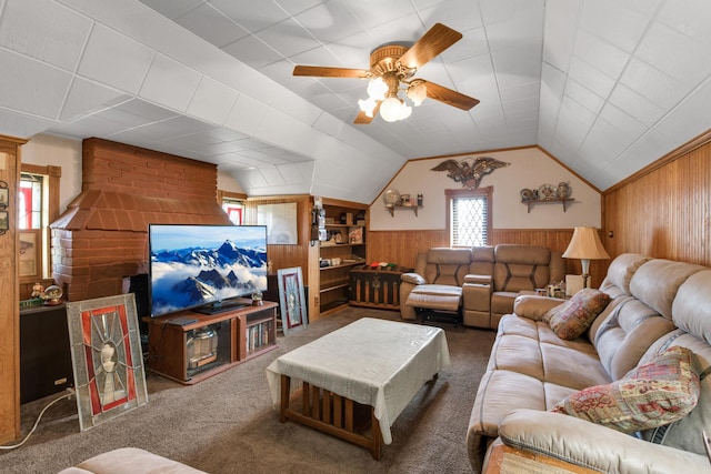 carpeted living room featuring lofted ceiling, wood walls, and ceiling fan