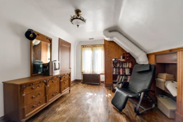 sitting room featuring hardwood / wood-style flooring, radiator heating unit, and lofted ceiling