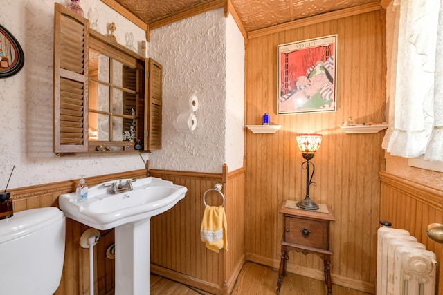 bathroom featuring ornamental molding, toilet, radiator, and hardwood / wood-style flooring