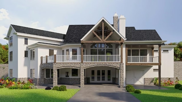 exterior space featuring a balcony, a yard, and a garage