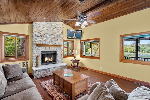 living room with wood ceiling, a stone fireplace, dark hardwood / wood-style floors, vaulted ceiling, and ceiling fan