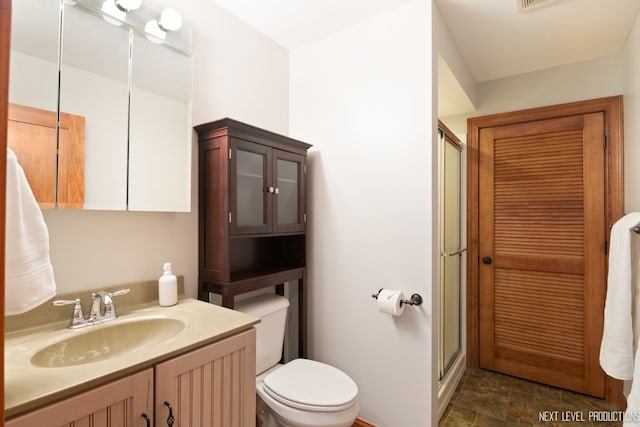 bathroom with toilet, walk in shower, and vanity