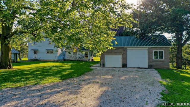 view of front facade with a front yard, an outdoor structure, and a garage