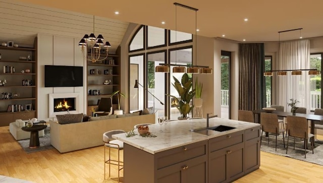 kitchen featuring gray cabinetry, sink, decorative light fixtures, light hardwood / wood-style flooring, and light stone counters