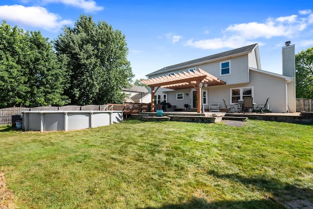 back of property with a pergola and a lawn