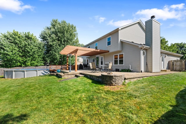 rear view of house featuring a pergola, a yard, and a patio area