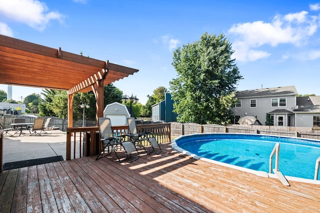 view of swimming pool with a wooden deck, a patio, and a pergola