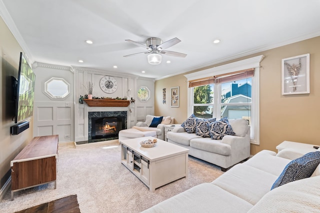 living room with crown molding, light carpet, ceiling fan, and a premium fireplace