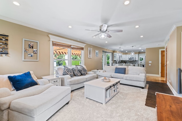 living room featuring ornamental molding, ceiling fan, and light hardwood / wood-style flooring