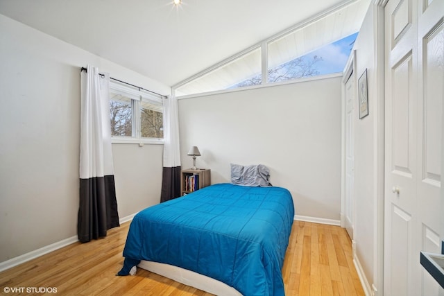 bedroom featuring wood-type flooring and vaulted ceiling