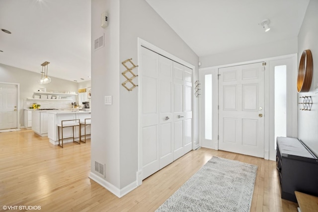 entryway featuring lofted ceiling and light wood-type flooring