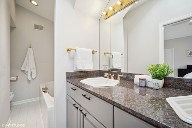 bathroom featuring lofted ceiling, vanity, toilet, and tile patterned flooring