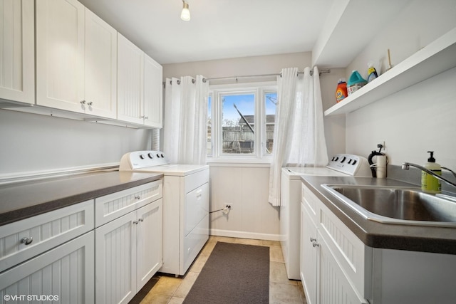 clothes washing area with independent washer and dryer and sink