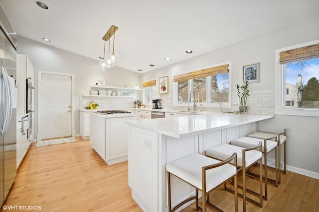 kitchen with white cabinetry, plenty of natural light, pendant lighting, and kitchen peninsula