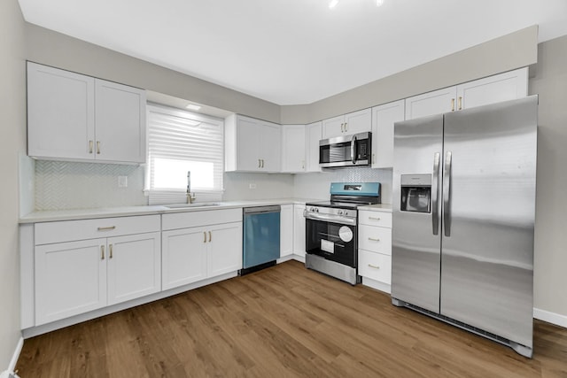 kitchen featuring stainless steel appliances, white cabinetry, and sink