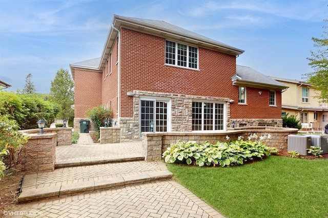 back of house featuring central AC unit, a lawn, and a patio