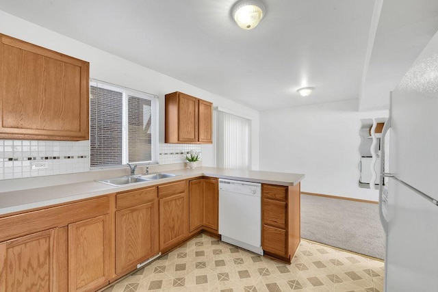 kitchen with sink, white appliances, kitchen peninsula, and tasteful backsplash