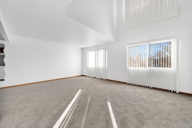 empty room with a high ceiling and carpet