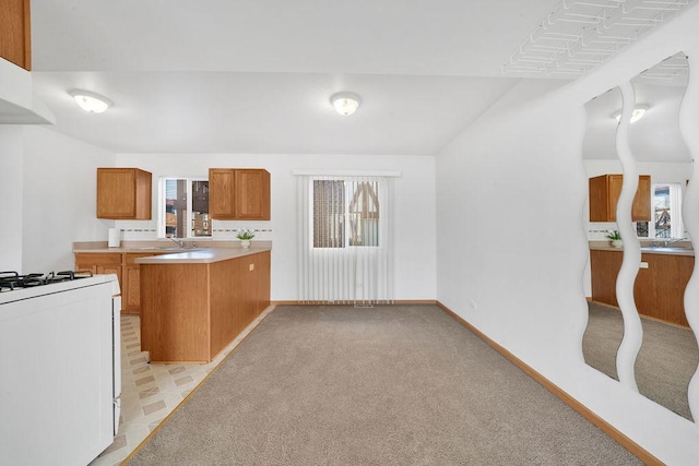 kitchen featuring sink, exhaust hood, light colored carpet, and white range with gas cooktop