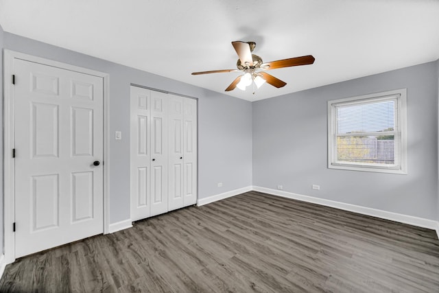 unfurnished bedroom with ceiling fan, two closets, and dark hardwood / wood-style flooring