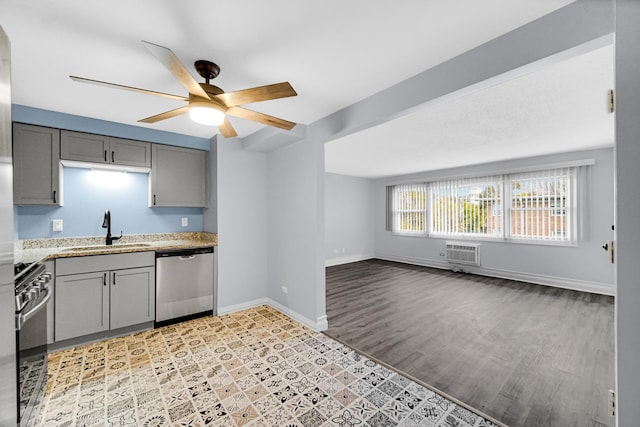 kitchen with appliances with stainless steel finishes, gray cabinetry, sink, ceiling fan, and a wall mounted AC