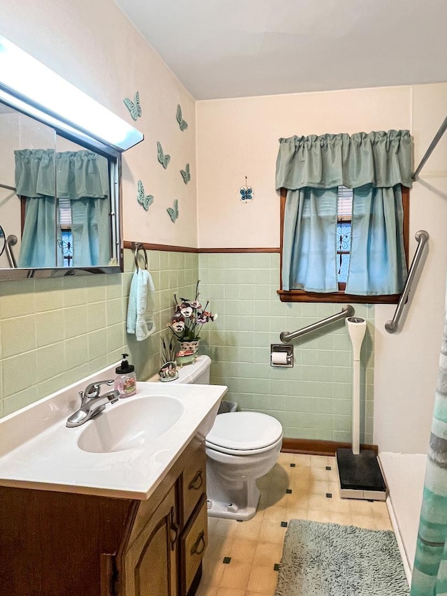 bathroom with tile walls, toilet, and vanity