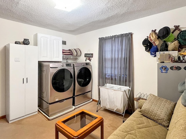 clothes washing area with cabinets, a textured ceiling, light carpet, and independent washer and dryer