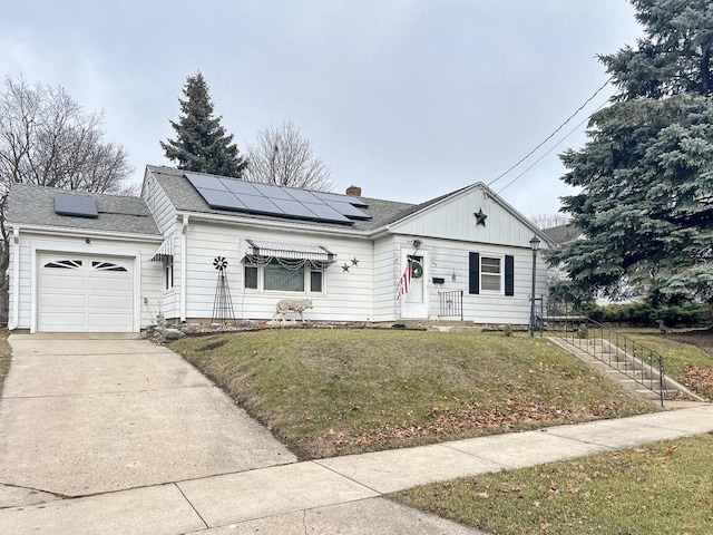 ranch-style house featuring a garage, a front yard, and solar panels