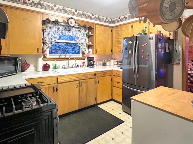 kitchen with sink, stainless steel fridge, and range with gas cooktop