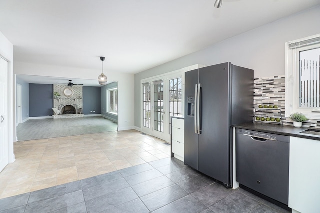 kitchen with hanging light fixtures, ceiling fan, backsplash, a fireplace, and stainless steel appliances