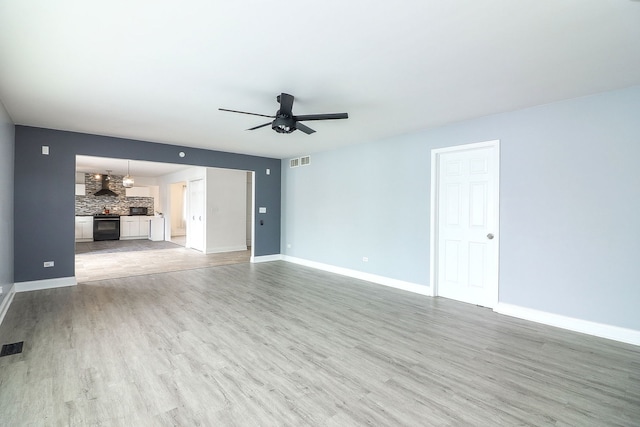 unfurnished living room with ceiling fan and light hardwood / wood-style floors