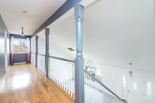 corridor featuring ornate columns and light wood-type flooring