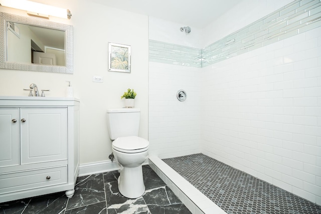 bathroom featuring tiled shower, vanity, and toilet