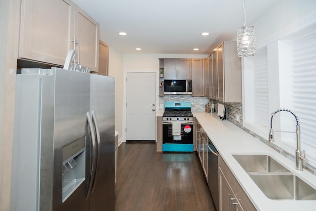 kitchen featuring appliances with stainless steel finishes, light brown cabinets, sink, backsplash, and hanging light fixtures