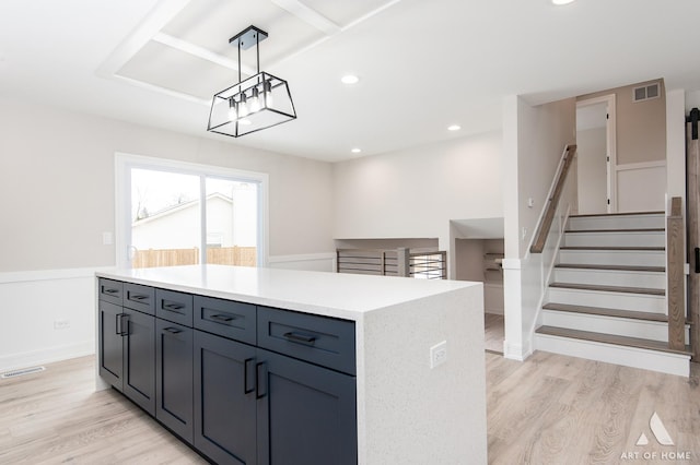 kitchen featuring hanging light fixtures, a center island, and light hardwood / wood-style flooring