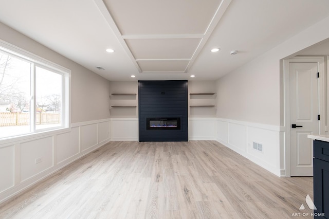 unfurnished living room featuring a fireplace and light hardwood / wood-style floors